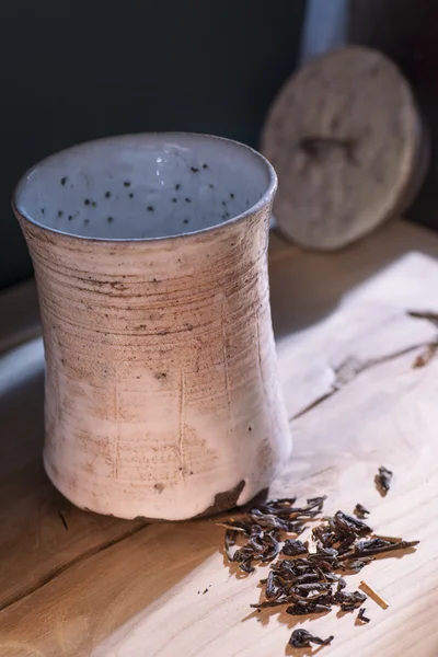 Ceramic cup of loose leaf tea on the table