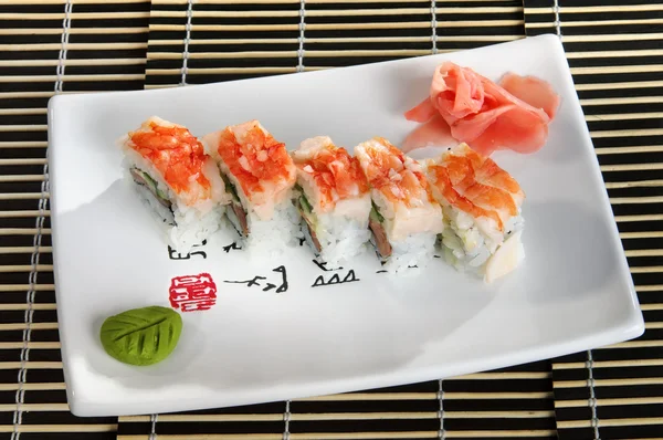 Sushi menu: a set of rolls of scallops with wasabi and ginger on a plate