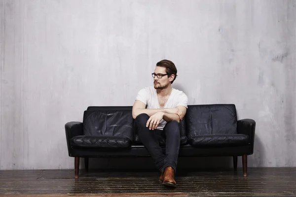 Young guy sitting on sofa