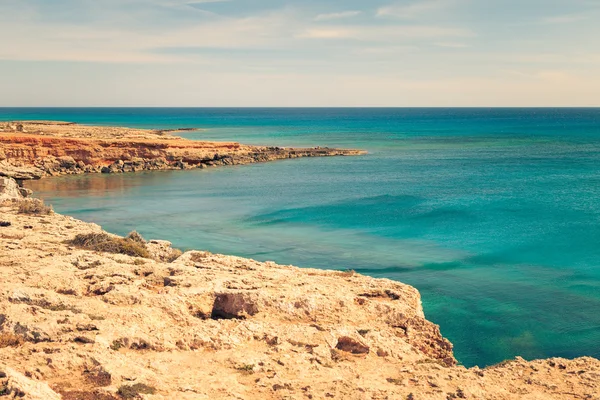Beautiful natural rock near of Ayia Napa, Cavo Greco and Protaras on Cyprus island, Mediterranean Sea. Amazing blue green sea and sunny day. Retro vintage toned image, film simulation.