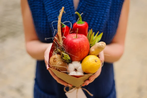 The original unusual edible vegetable and fruit bouquet in girl hands