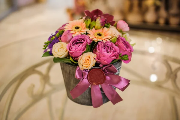 Small bouquet of pink and purple flowers  in box