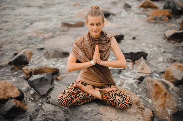 Woman meditating at the beach . yoga retreat. namaste in lotus pose