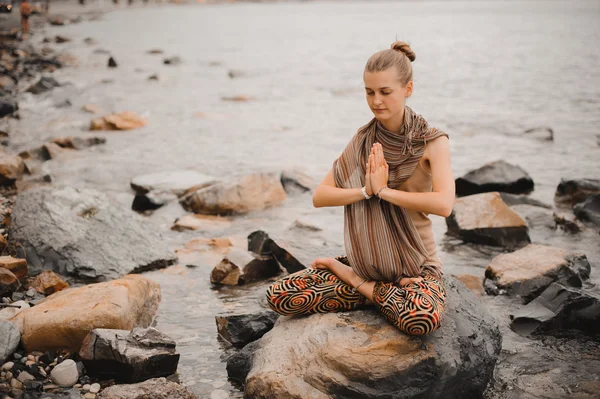 Woman meditating at the beach . yoga retreat. namaste in lotus pose