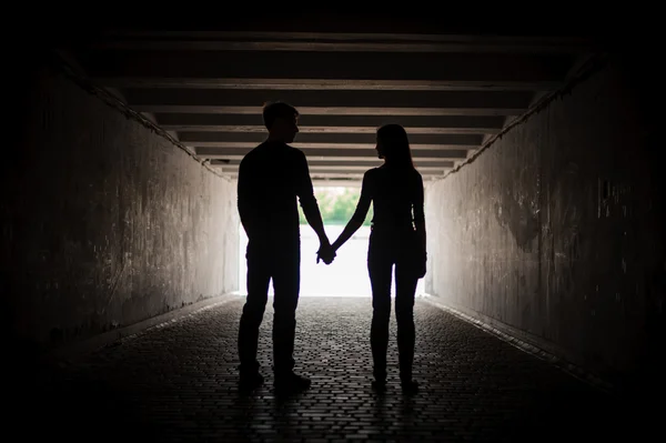 Silhouette of young couple holding hands