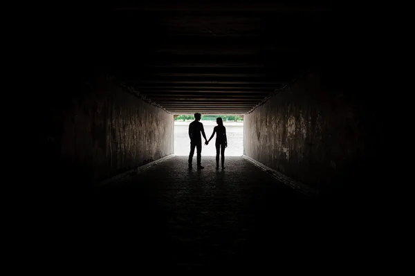 Silhouette of young couple holding hands