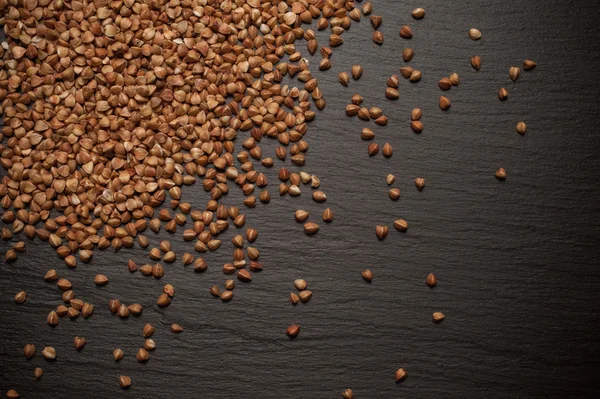 Buckwheat is sprinkled on black slate  stone