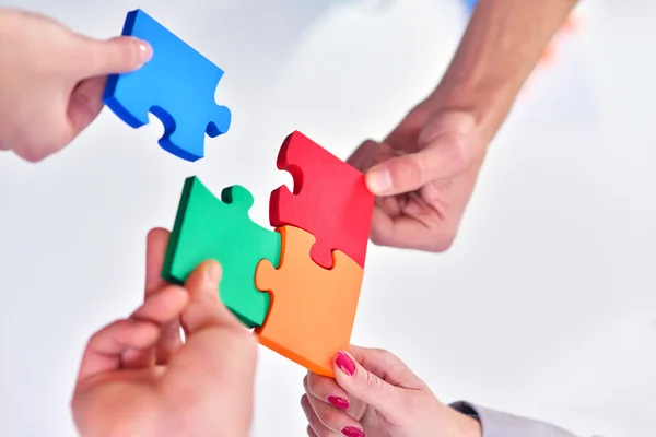 Business people assembling jigsaw