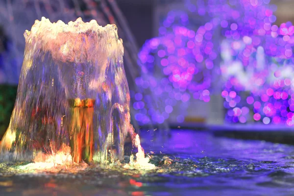 Small fountain with blue and yellow color illumination in the Mall. blurred background