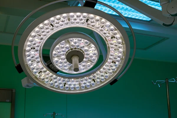 Surgical lamp in operation surgery room. Half brightness. Green cast light is on background open during the surgery. Can be used on your website, magazine, brochure or advertisement.