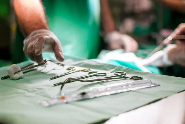 Doctor taking surgery tools from the table in operation room. Great background for your magazine, brochure or other printed media