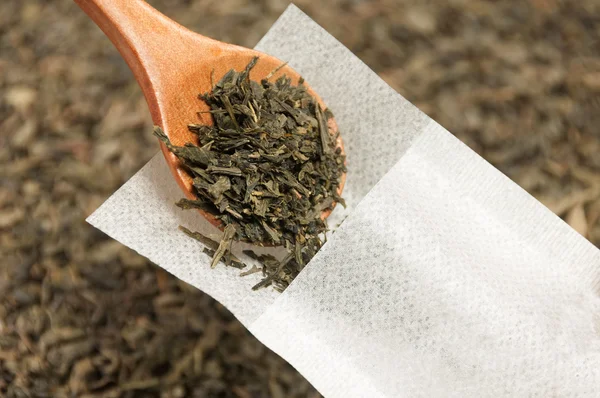 Green tea is filled with wooden spoon into a special tea filter