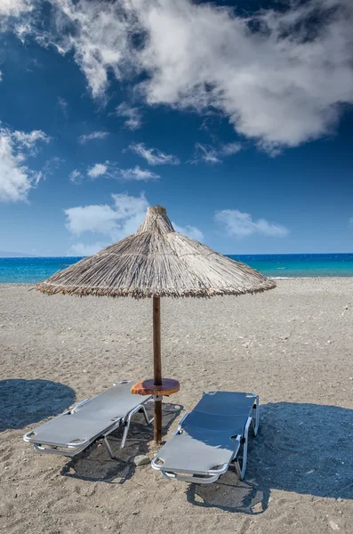 Straw umbrella on a sandy beach in Greece.