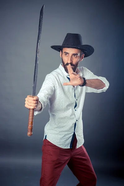 Man in casual dress code with hat and sword
