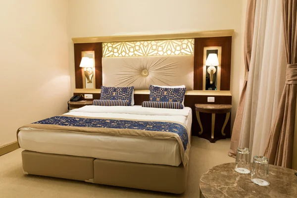 Luxury hotel room with comfortable bedroom and modern decor.