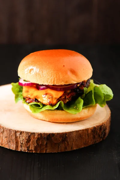 Delicious fresh homemade burger on dark serving board with spicy