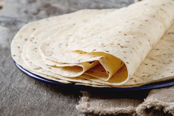 Tartilla sheets on a gray background. Brown cloth. Mexican food.