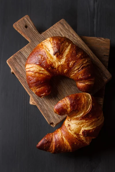 French food for breakfast. Fresh baked croissants. Dark wood bac