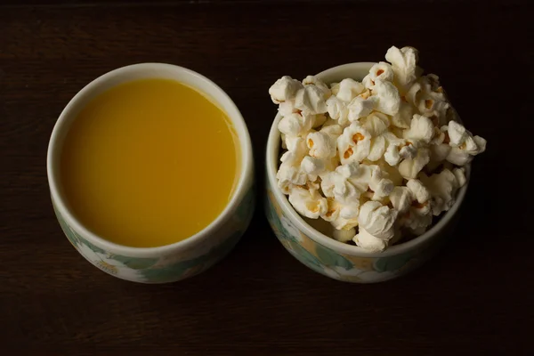 Cups of popcorn and orange juice
