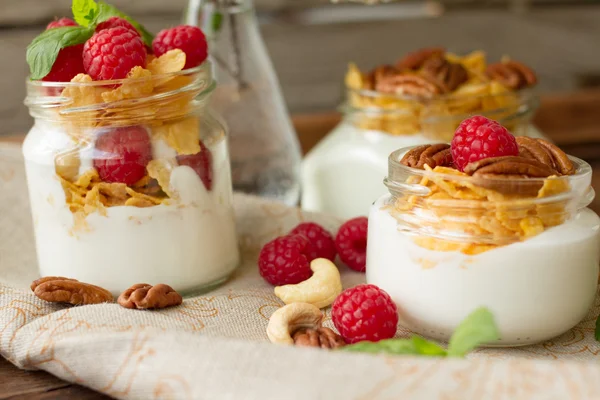 Yogurt for breakfast with nuts, raspberry and milk. Diet for Women