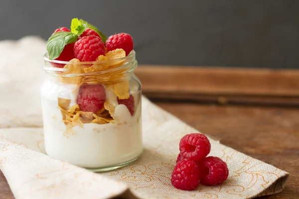 Yogurt for breakfast with nuts, raspberry and milk.