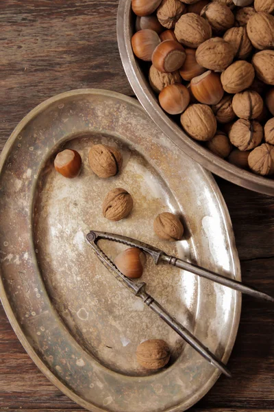 Mixture of nuts on metal plates with vintage orehokolom
