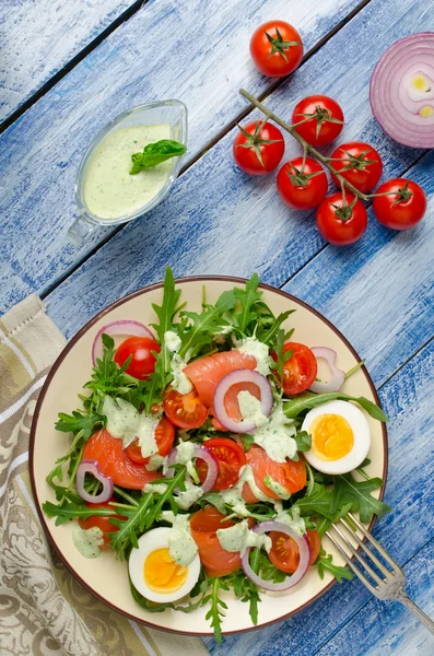 Smoked salmon salad with arugula, tomatoes, eggs and red onion