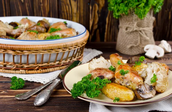 Baked chicken legs with potatoes, champignon and cauliflower