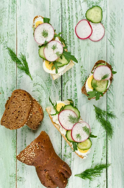 Sandwiches with egg, radish, cucumber and arugula