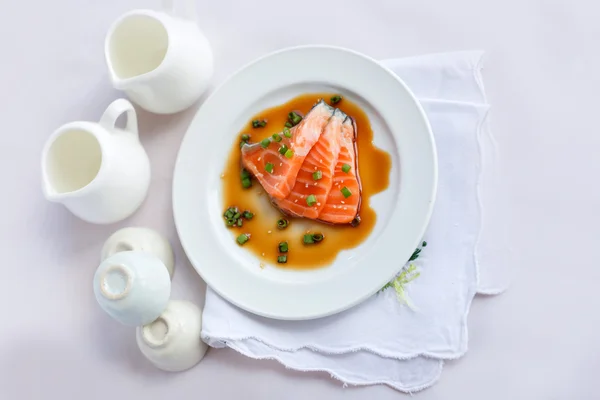 Salmon fillet with sauce on white dish