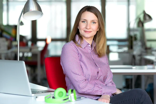 Smiling Business Lady in casual clothing sitting at Office Table
