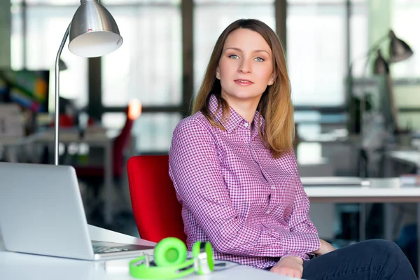 Charismatic Business Lady in casual clothing sitting at Office Table