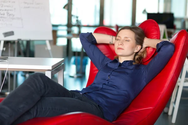 Business Person relaxing in red Chair at modern creative Office