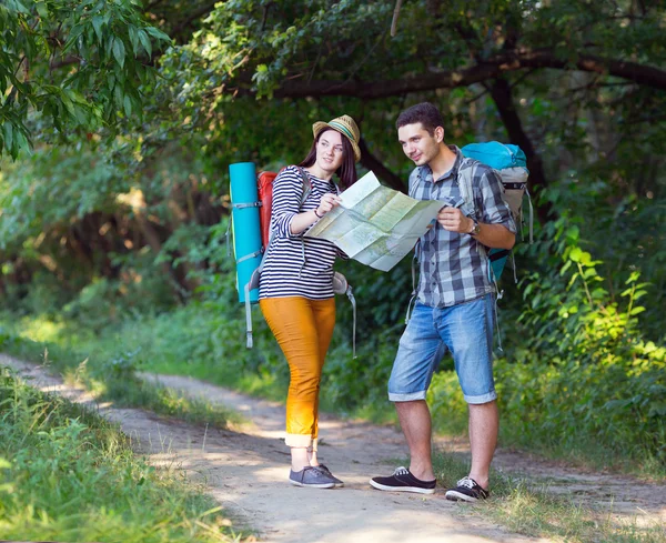 Young Hikers looking into Map on Forest Trail