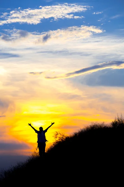 Silhouette of female with raised hands