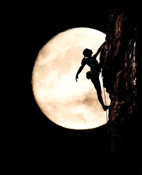 Female climber silhouette and large full moon background