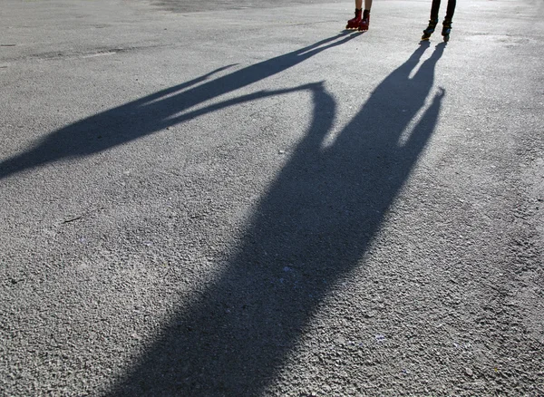 Shadows of skaters on asphalt