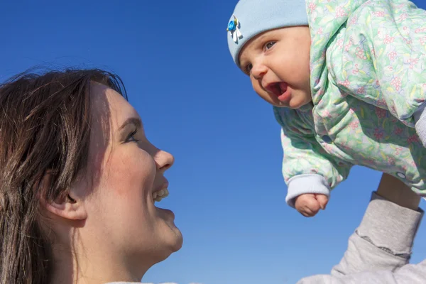 Mother and baby on blue sky background