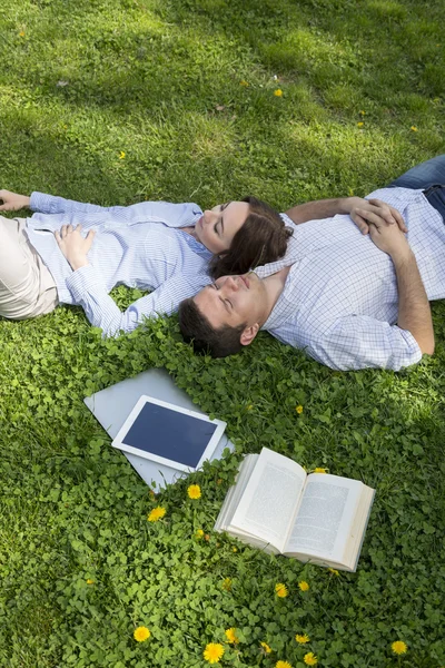 Young man and woman napping on grassy lawn