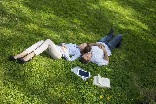 Two people napping on grassy lawn