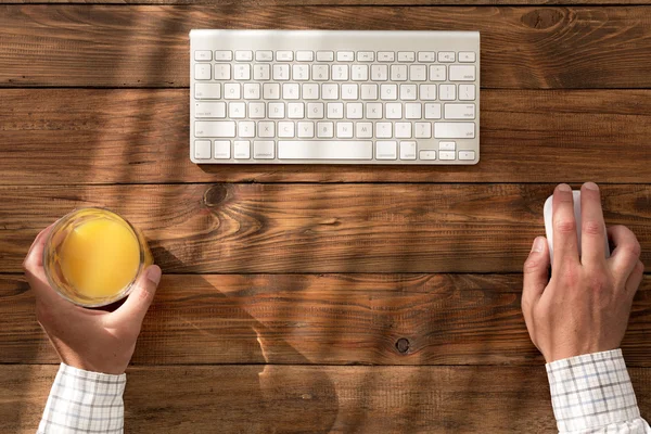 Top view of man at natural wooden desk