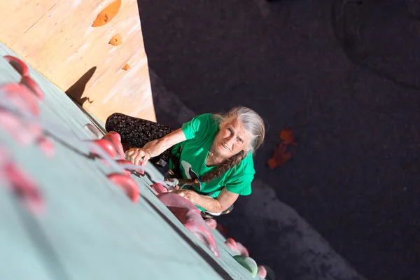 Aged Woman Climbing Wall