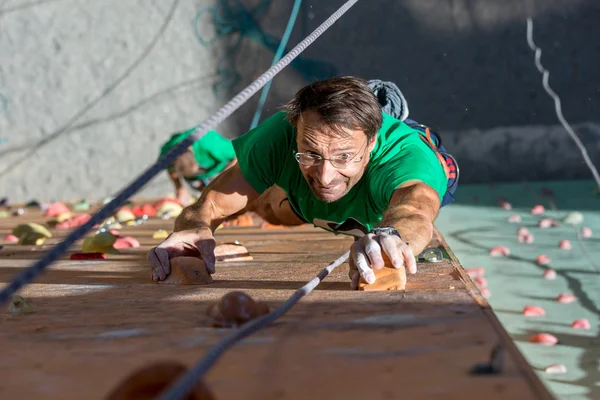 Mature Athlete Trying to Reach Out Next Climbing Hold