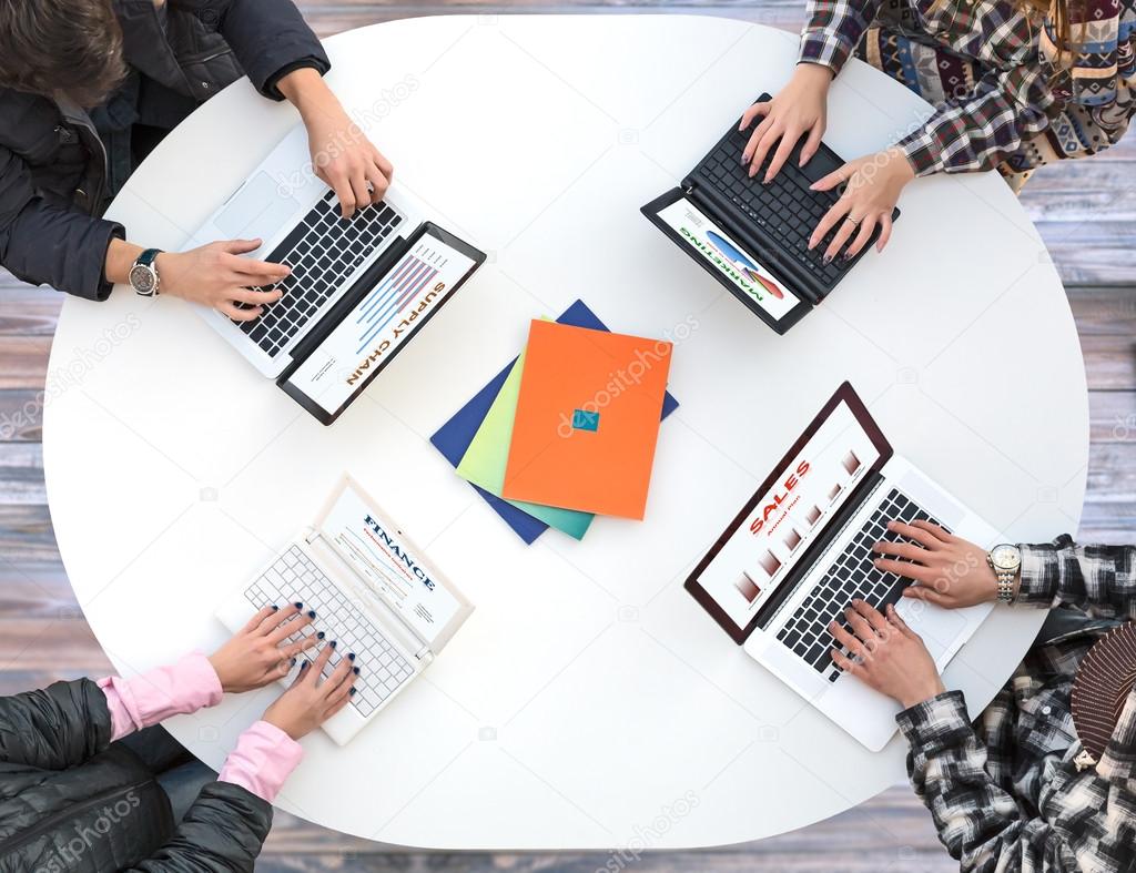 Top View Of White Rounded Desk With Four Laptops And People Hands White Office Round Table And Men Women Working On Computer Top View Casual Clothing Typing Keyboard Many Laptops Charts Related To Corporate