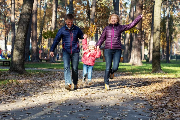 Young Family in Autumnal Forest Running