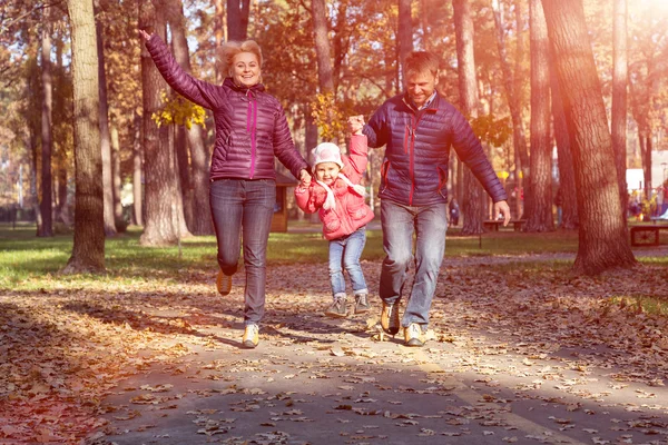 Young Family in Autumnal Forest Running