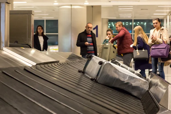 Luggage Belt at Airport Terminal with Bags and Passengers