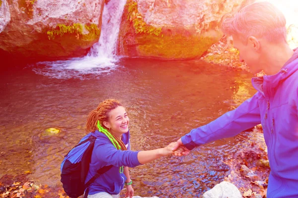 Two Hikers young Man and Smiling Woman holding hands Sunny