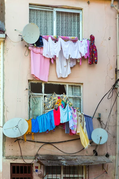 Clothing hanging on clothesline next to windows of old house