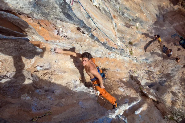 Top View of Rock Climber on orange Vertical Wall